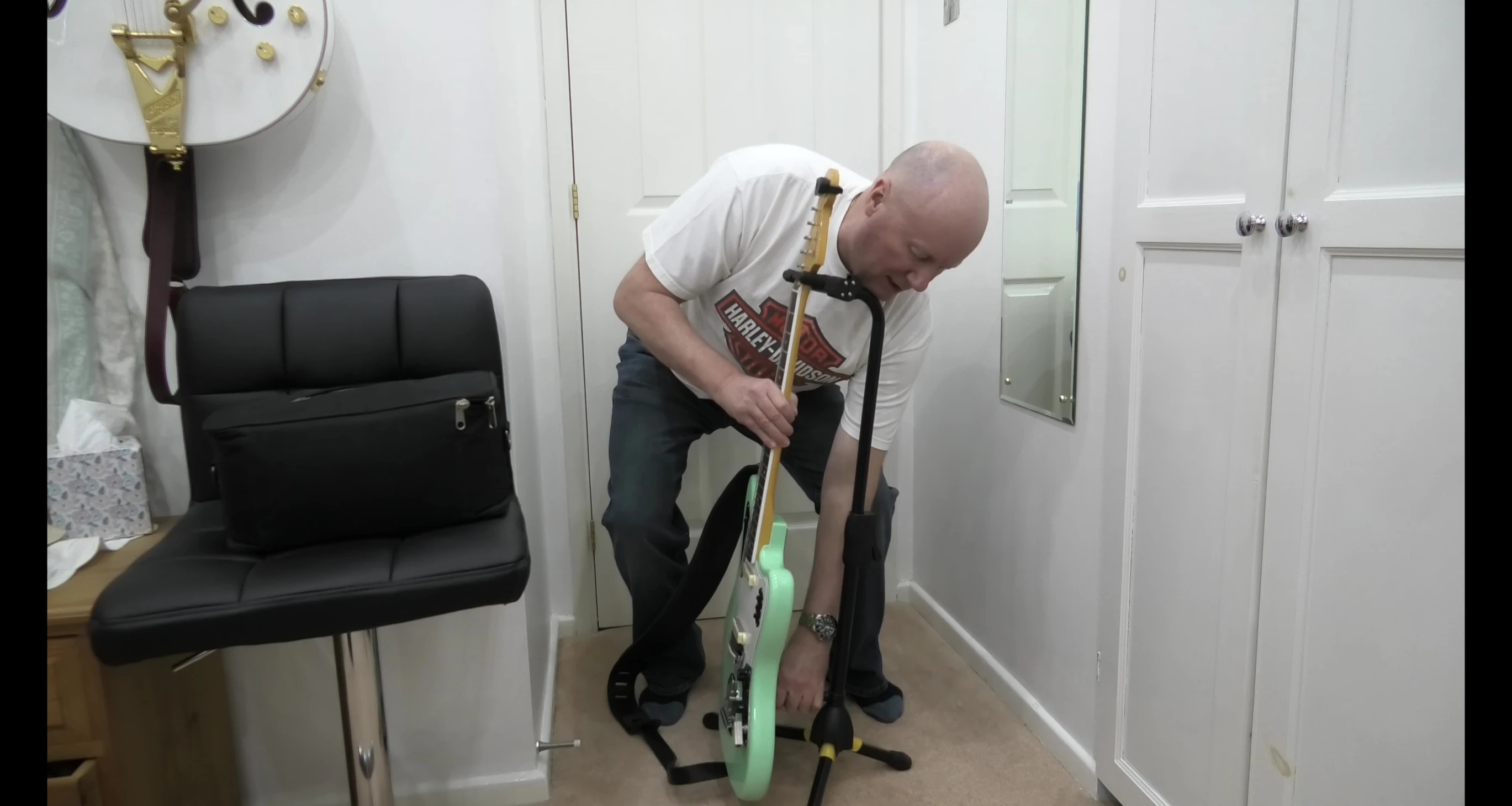 Adjusting the back of the stand for optimal guitar placement.