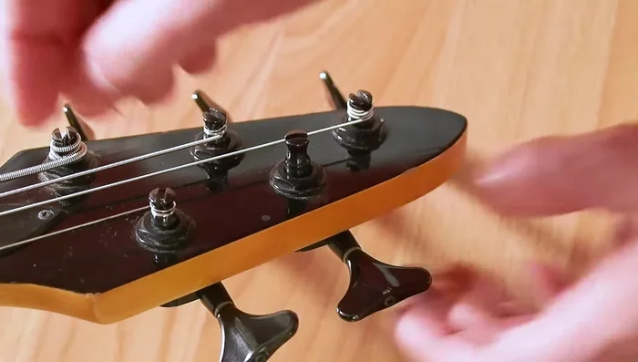 Access the screw by carefully removing the cap on the back of the tuner. If the peg won't thread, use the wrench to gently tap the screw head, driving it into the cap and removing the cap.