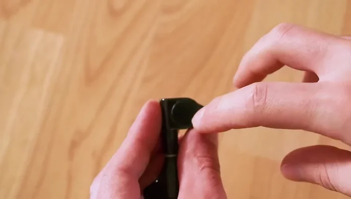 Access the screw by carefully removing the cap on the back of the tuner. If the peg won't thread, use the wrench to gently tap the screw head, driving it into the cap and removing the cap.