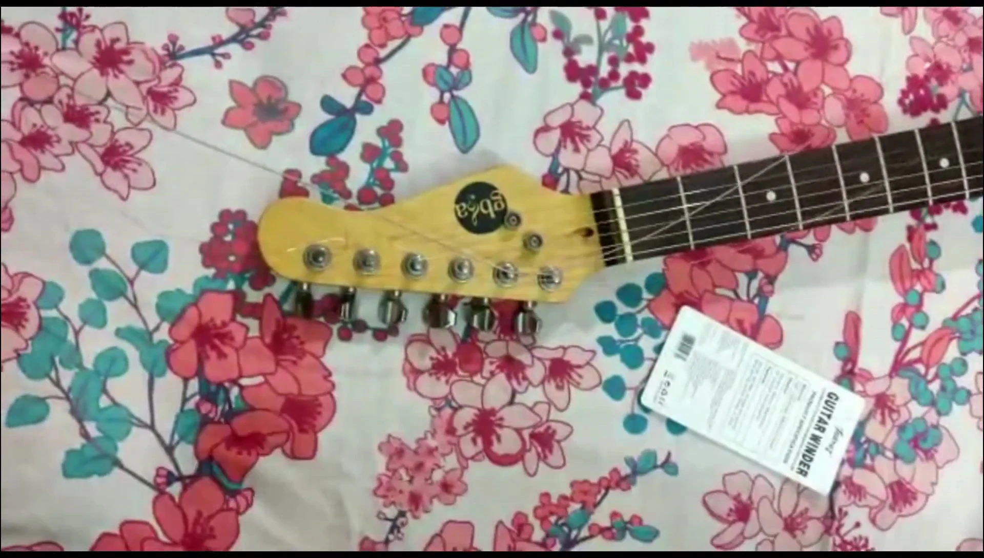 The reviewer holding the guitar, ready to use the tool