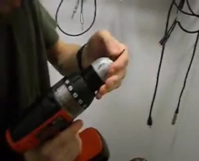 Using a 3/32 inch drill bit, drill a hole through the center of the tuner handle.