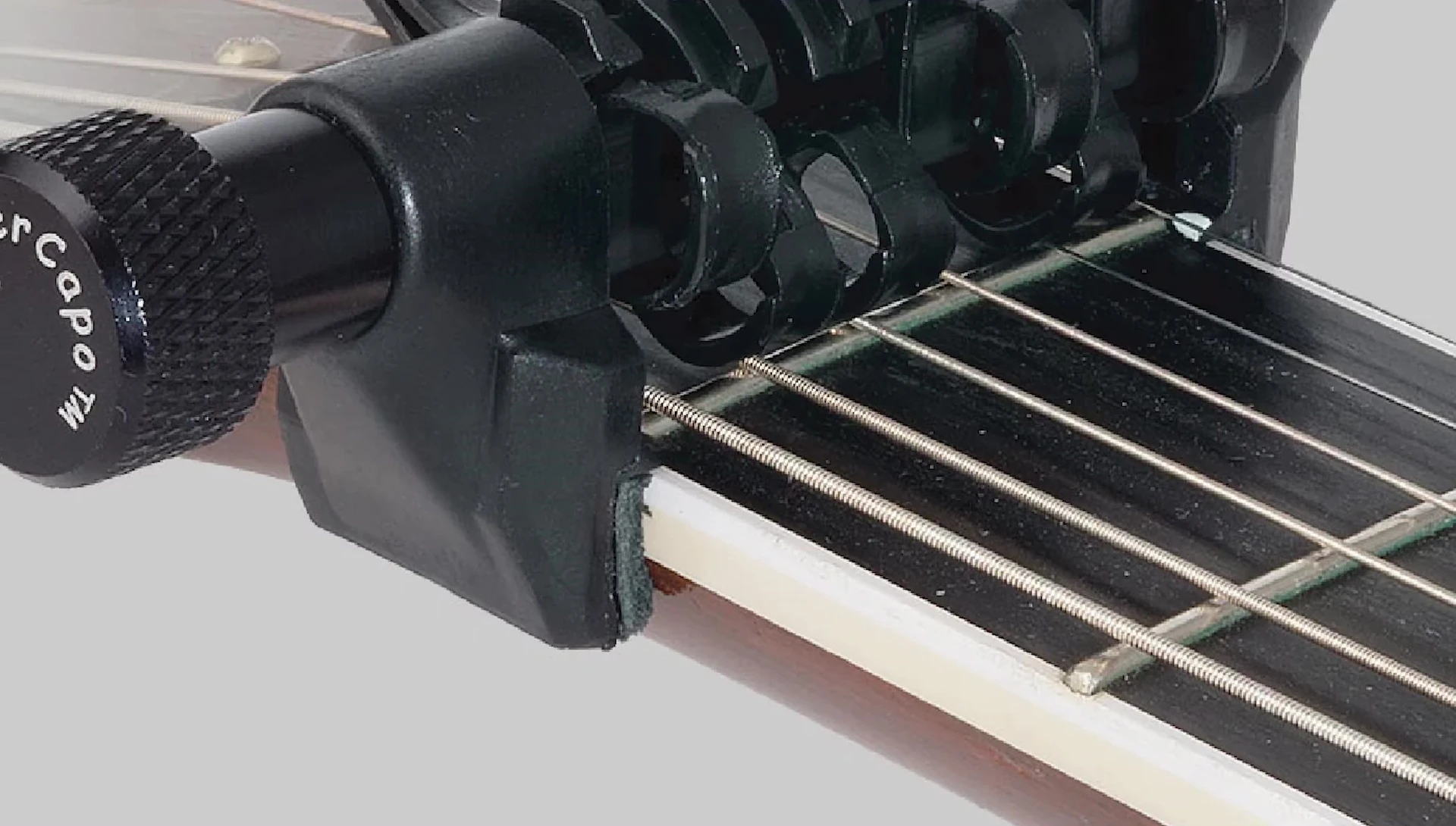 Creative Tunings Spider Capo on guitar, showing multi-string fretting
