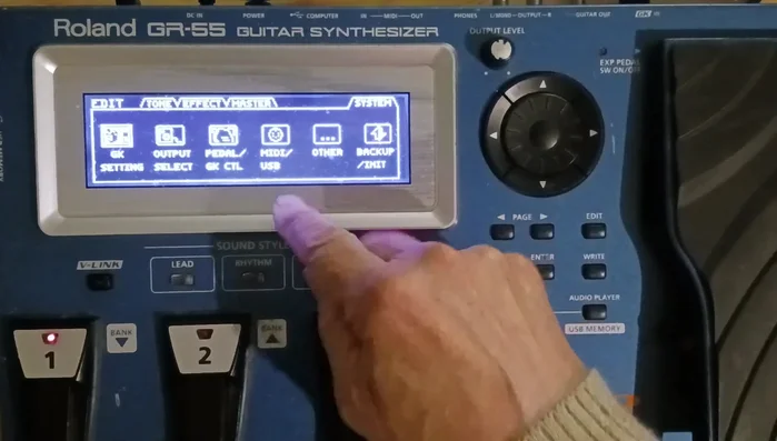 Navigate to GK Settings: Use the page buttons (left/right arrows) to move to the 'System' page, then select 'GK settings'.