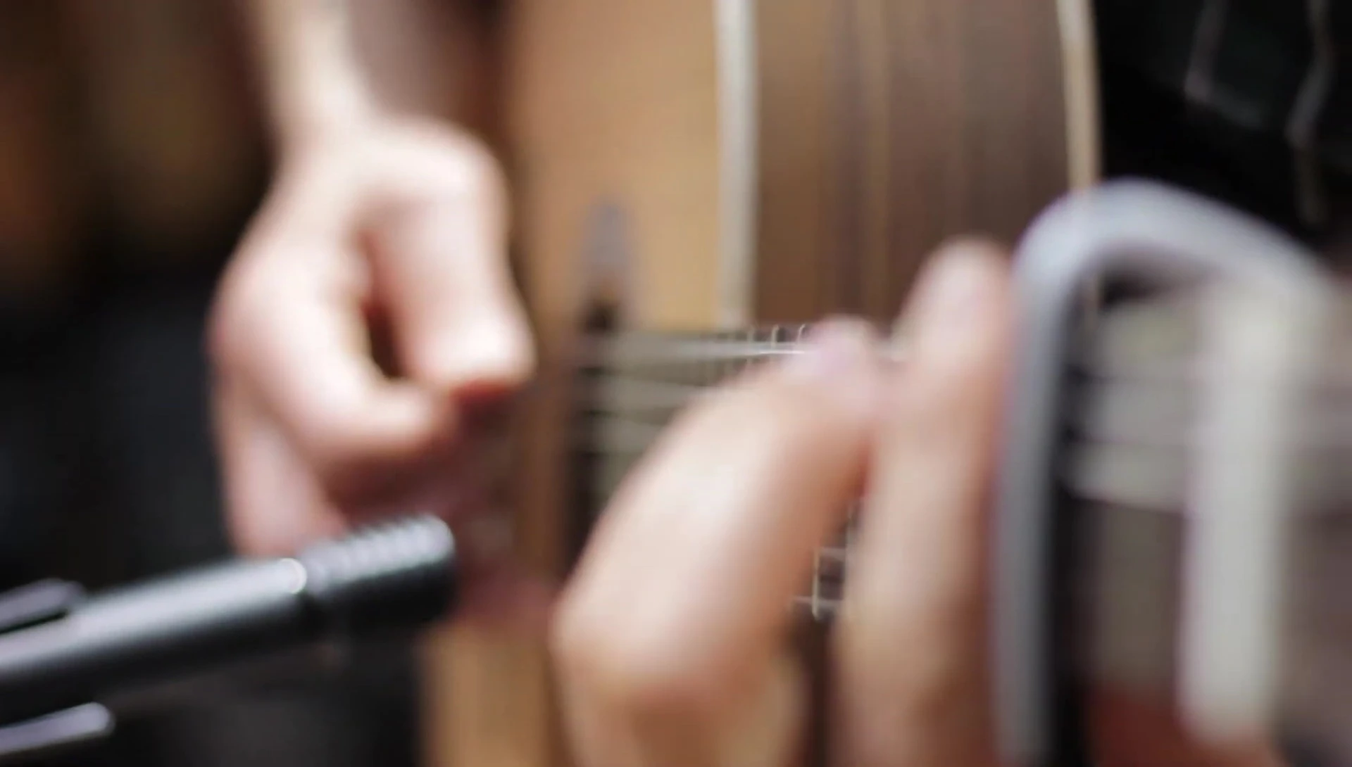 The capo on the guitar fretboard, highlighting its robust construction.
