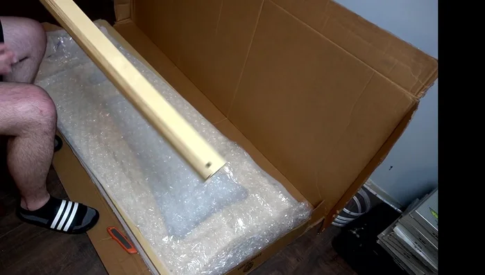 Identify the wooden arms and side panels in the packaging.