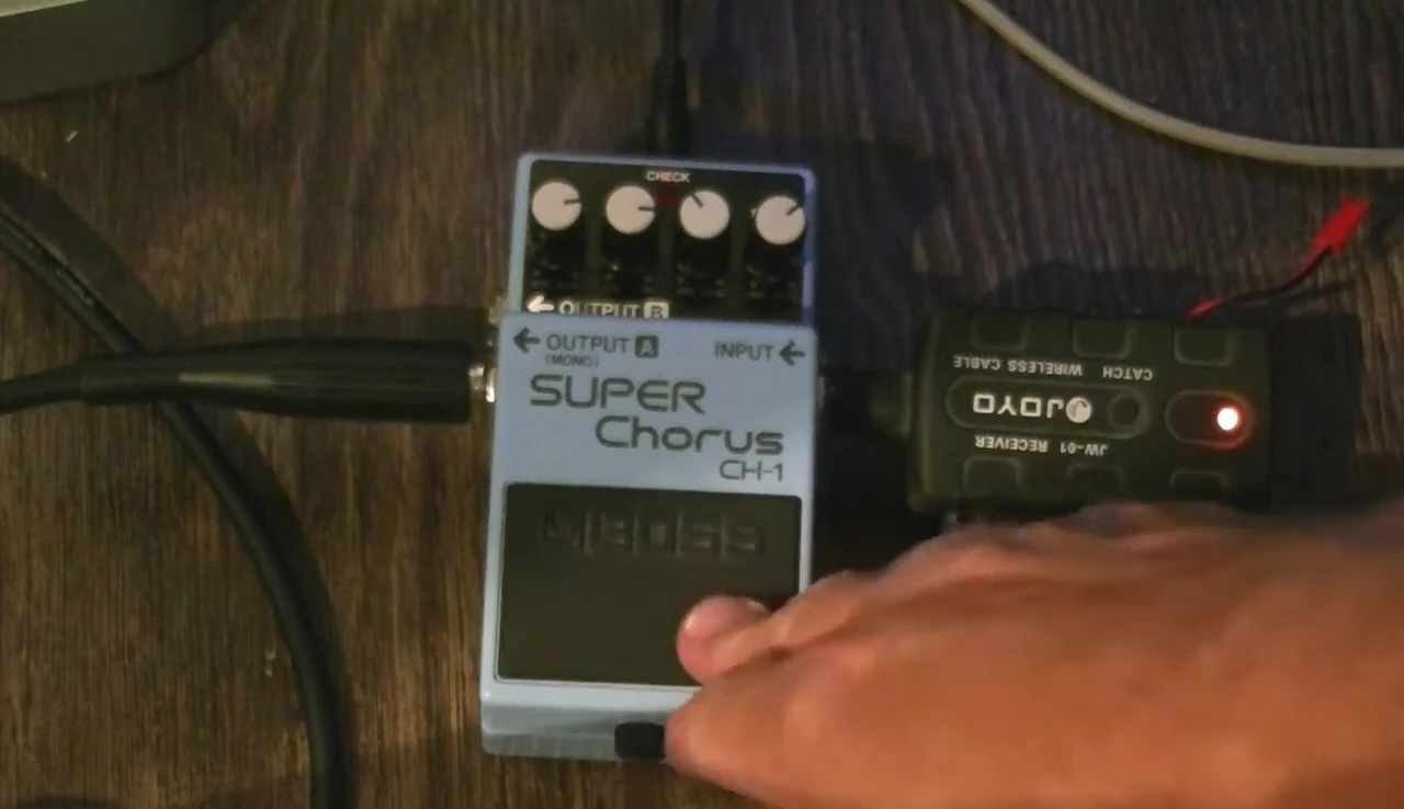 The reviewer holding up the Boss CH-1 Super Chorus pedal.