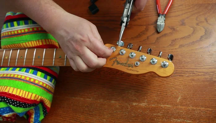 Remove old strings from tuning pegs.