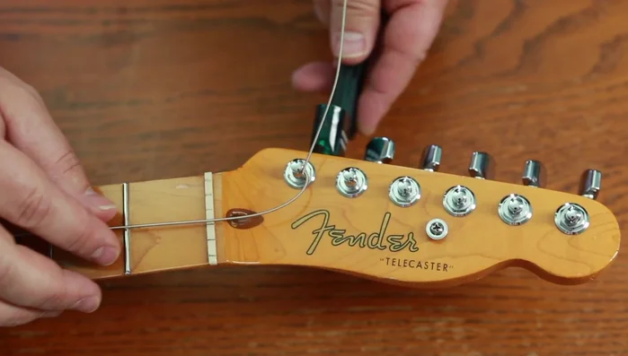 Tune string to pitch.