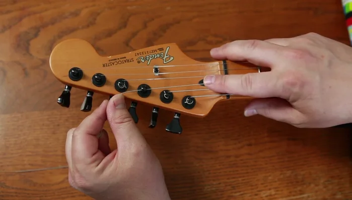Insert string through locking tuner, tighten the lock, and turn.