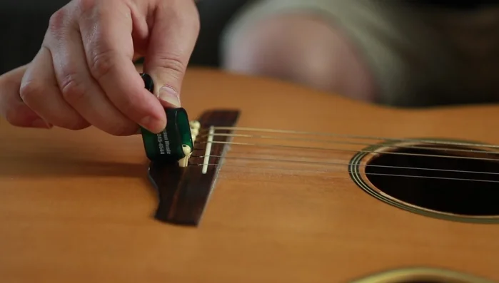 Remove bridge pins using string winder's notch.