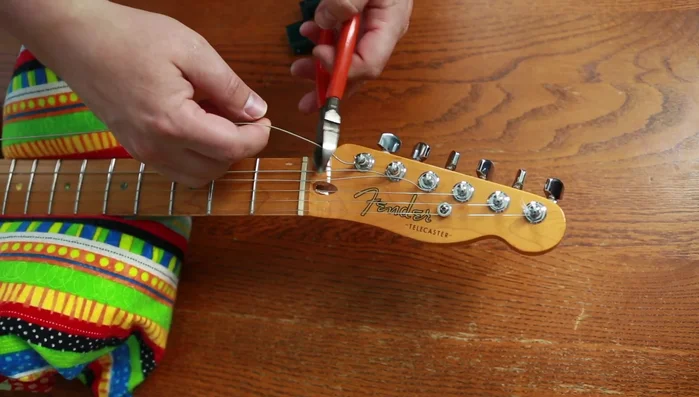 Remove old strings from tuning pegs.