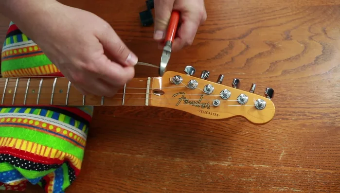 Remove old strings from tuning pegs.