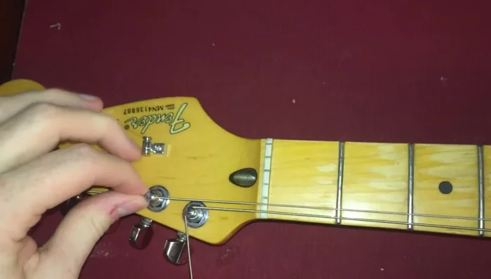 Tighten the string, ensuring the loop is secure. The loop should crimp against the adjacent string.