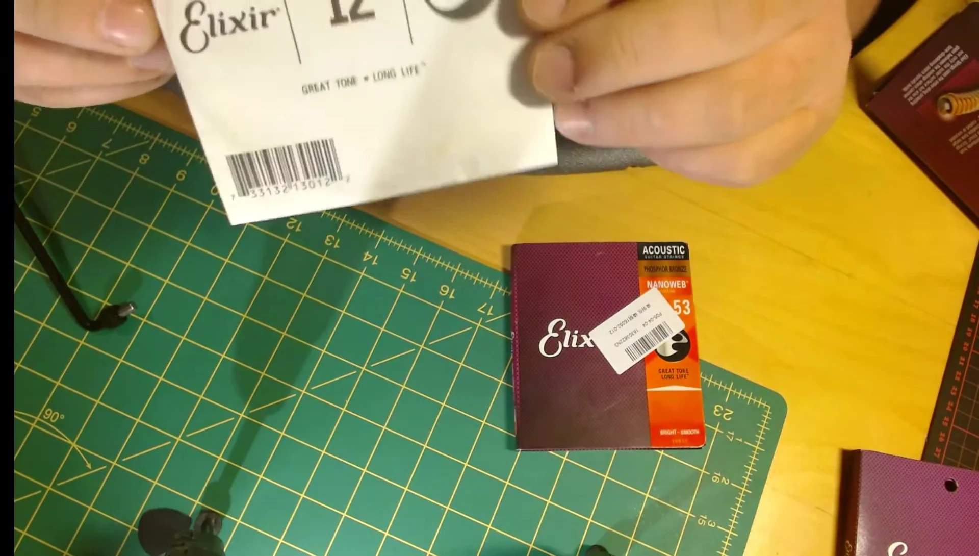 Close-up showing the dirty or rusty discoloration on fake Elixir string packaging.
