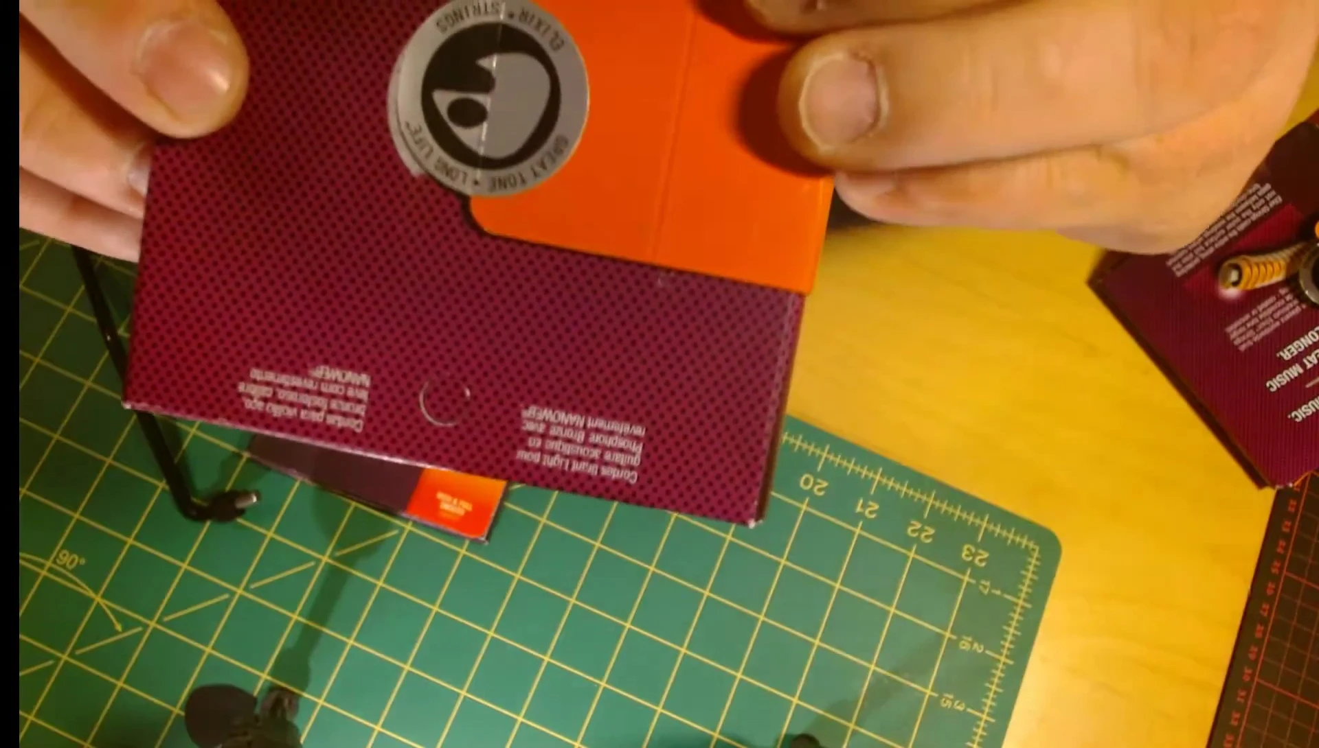 Comparison of the seals on fake and real Elixir strings, highlighting the difference in detail.