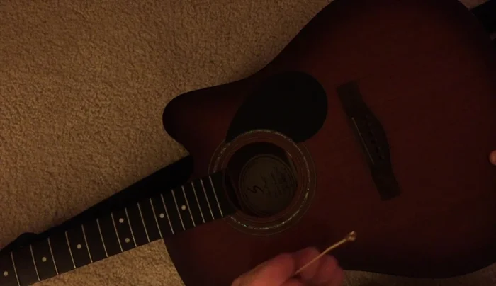 Wind the strings tightly around the tuning pegs, using finger pressure to control the wrapping.