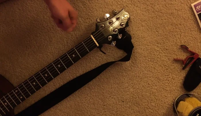 Remove old strings by loosening tuning pegs.