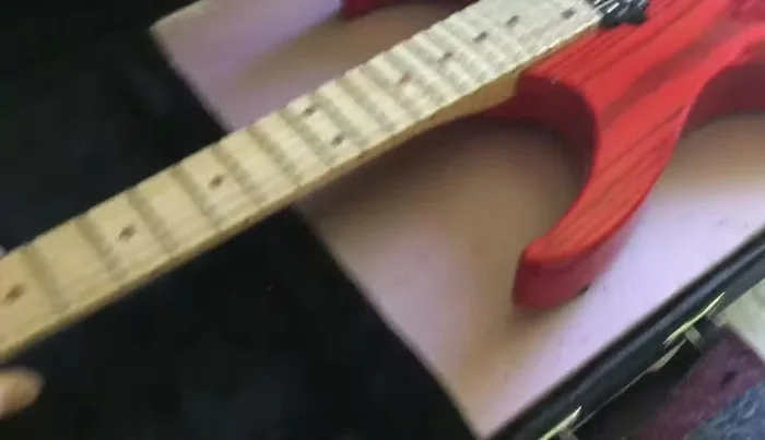 Cut out the traced shape, using a jigsaw for the main body and a belt sander (or alternative method) to shape the neck cutout.