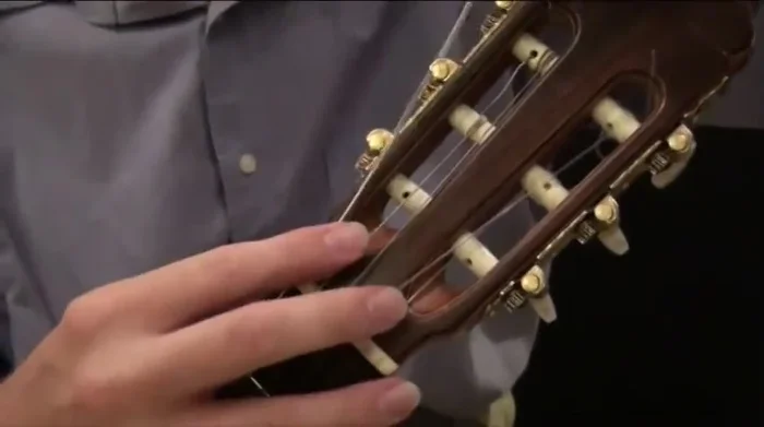 Place the string in the groove at the headstock (nut).