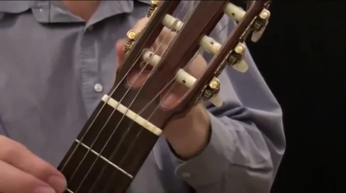 Remove the string from the bridge by slipping the loop forward and pulling it through.