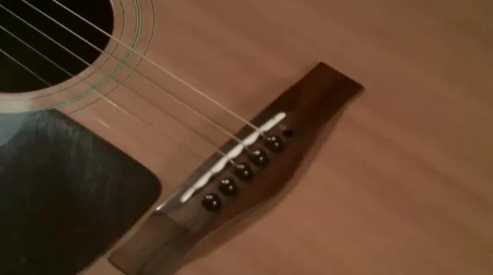 Insert the string into the tuning peg hole, ensuring the groove on the peg faces the string. Push it down and pull out as much string as possible.