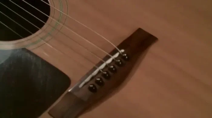 Remove the old string from the bridge pin.