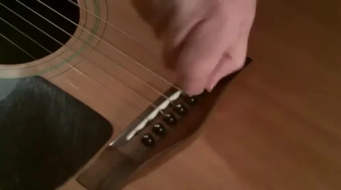 Remove the old string from the bridge pin.