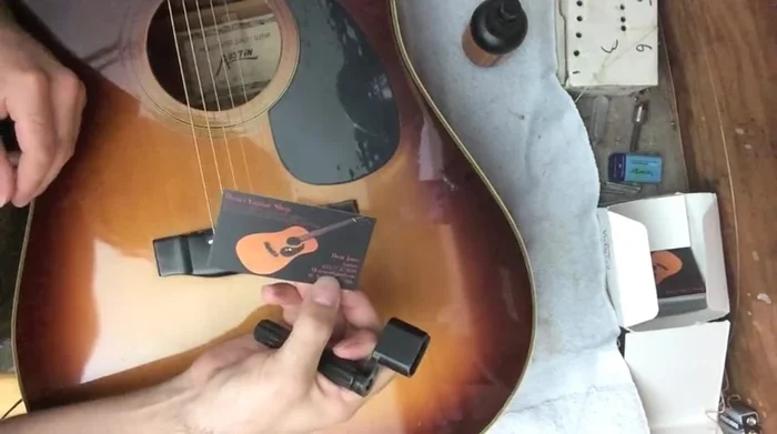 Employ a store-bought string winder/bridge pin puller. Place a business card under the puller to protect the bridge.