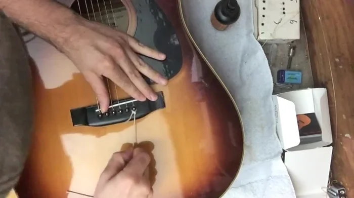 Use a string with a slip knot loop to gently pull the bridge pin out.