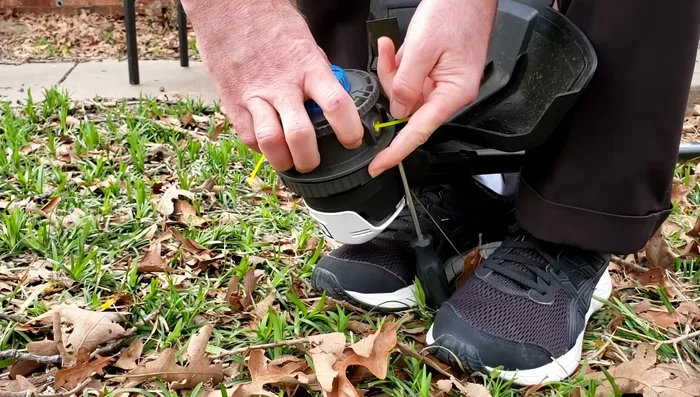 Hold the screwdriver in place with your feet and twist the top part of the head with both hands to open it.