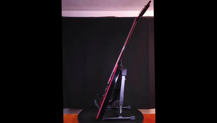 Testing different settings and observing the stand's stability and fit with various guitars.