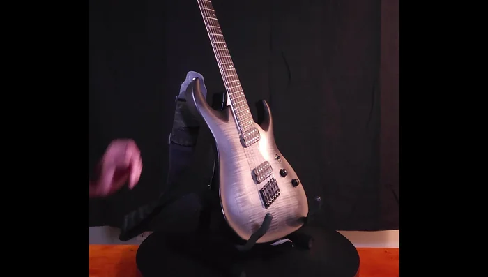 Testing different settings and observing the stand's stability and fit with various guitars.