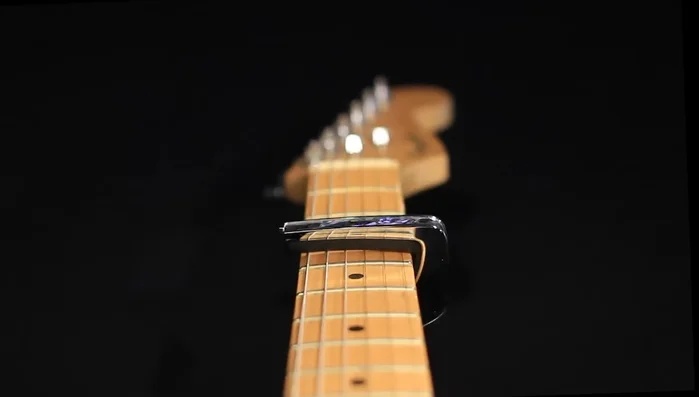 On guitars with a larger radius (like Taylor or Martin), the traditional capo applies too much pressure to the outer strings, causing tuning issues.